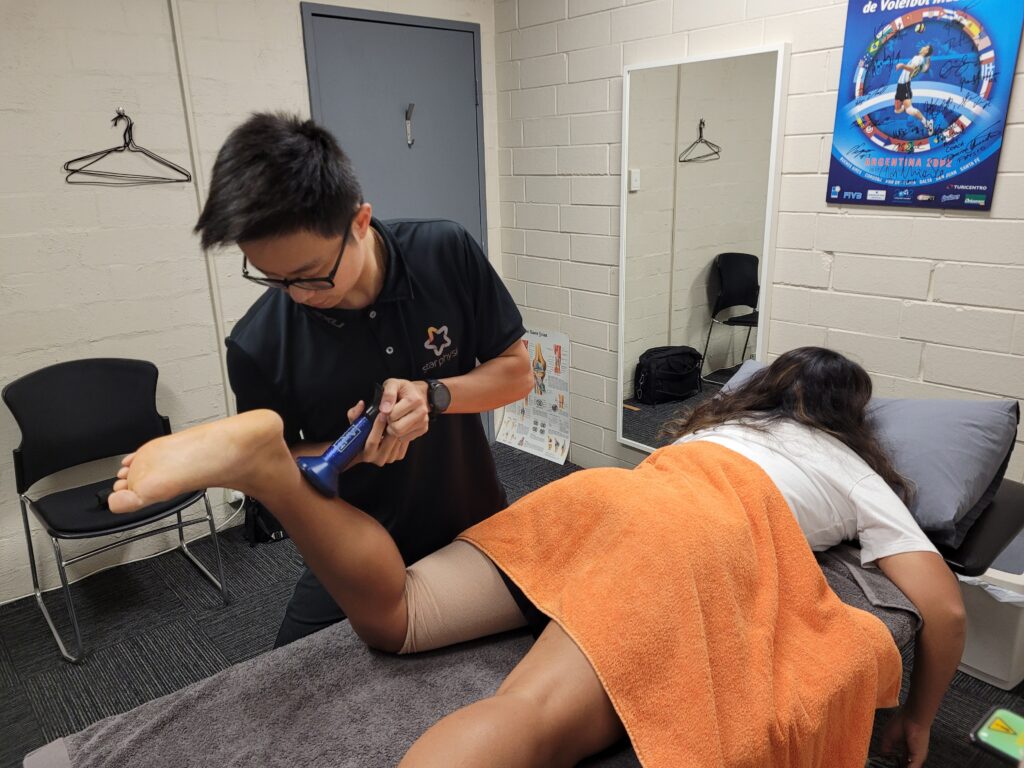 Physiotherapist Aaron Tay performing strength testing on a knee during post-operative rehabilitation at Star Physio Perth