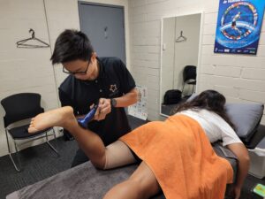 Physiotherapist Aaron Tay performing strength testing on a knee during post-operative rehabilitation at Star Physio Perth