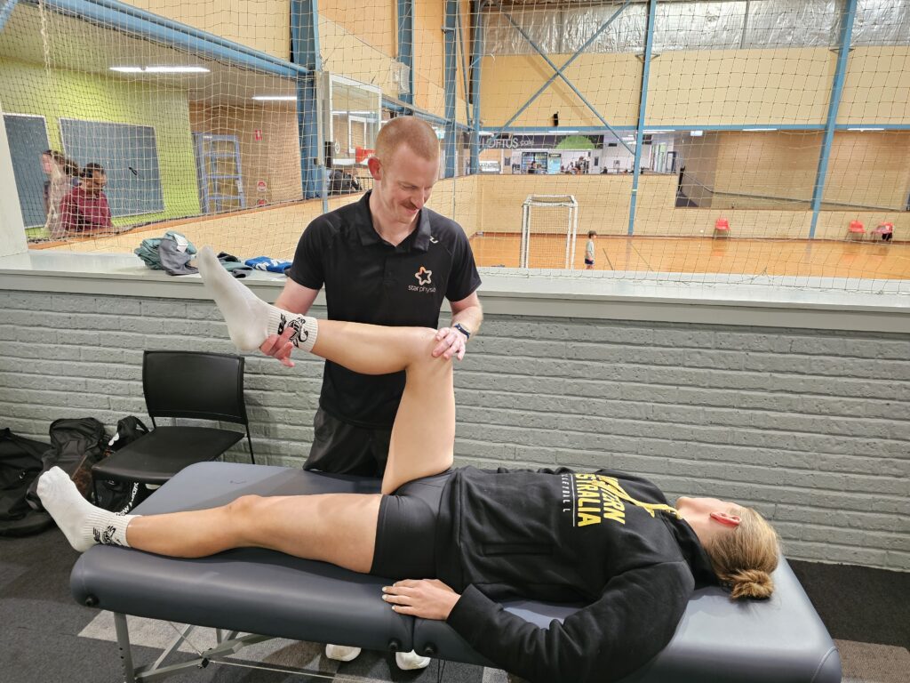 Cillian Madden providing physiotherapy to a volleyball player in Perth