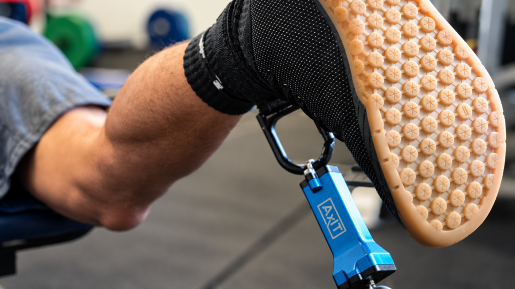 Close-up of lower-limb strength testing using AXIT equipment during physiotherapy rehabilitation
